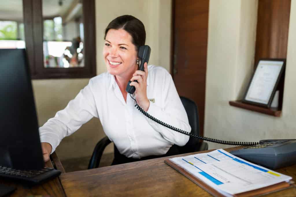 Receptionist answering phone at desk