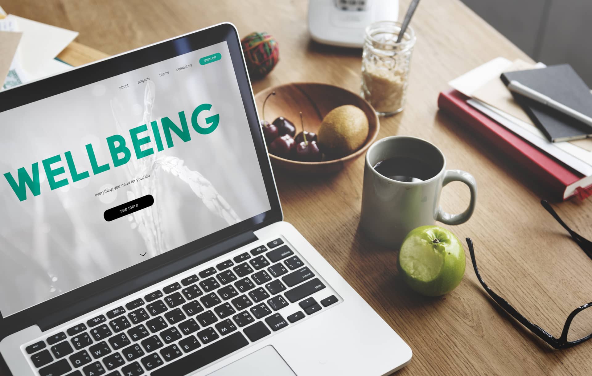 A laptop on a desk with wellbeing on the screen